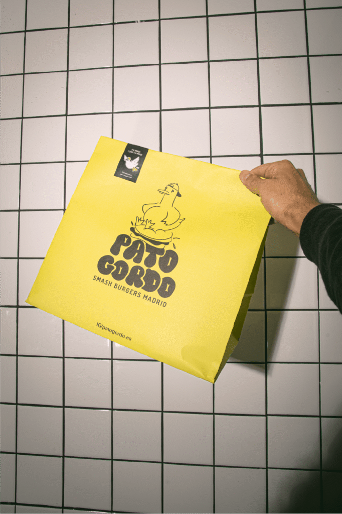 Un hombre sosteniendo una bolsa de Pato gordo amarilla